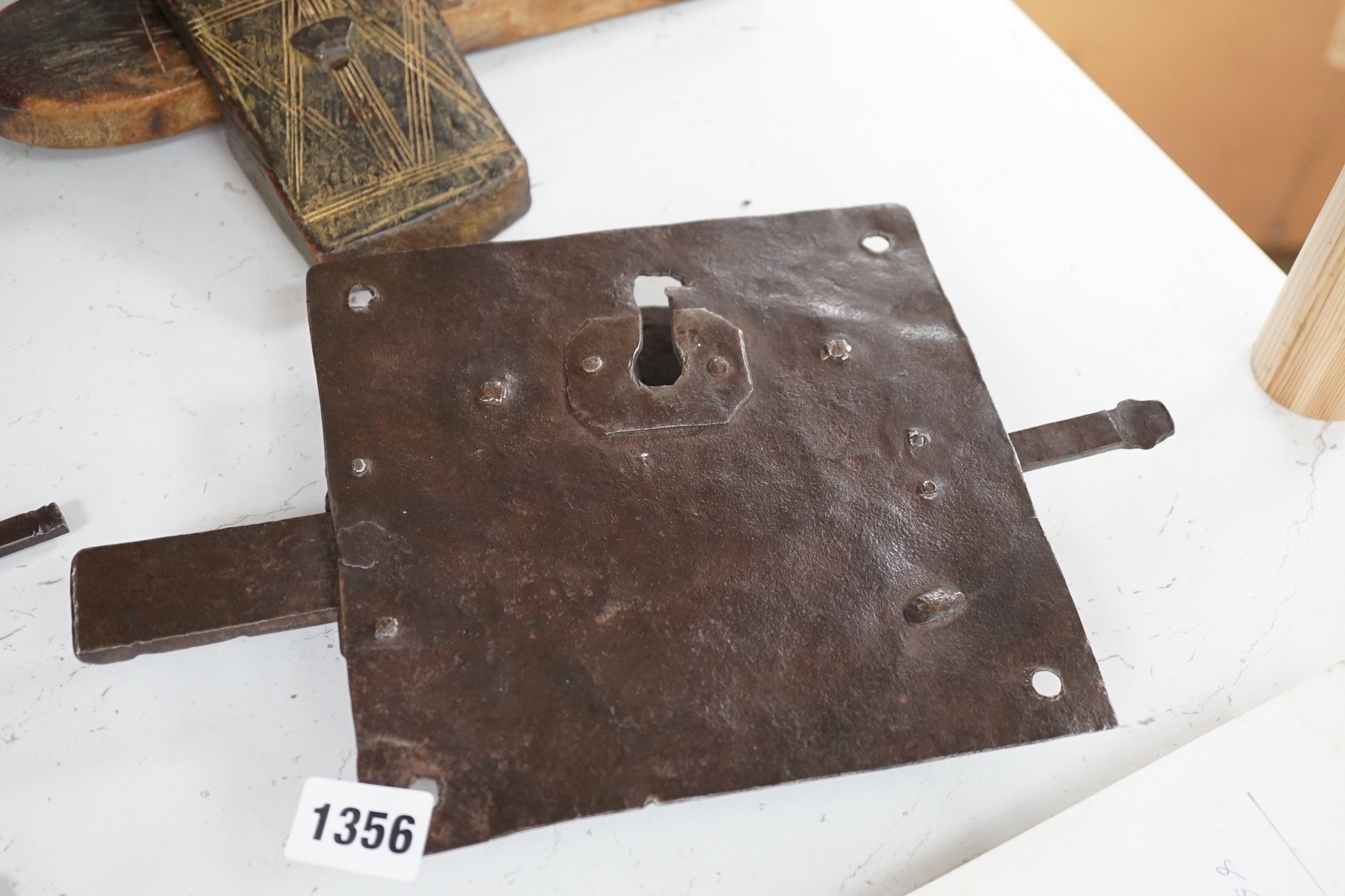 Three early ironwork lock plates with keys and a carved hardwood bolting lock